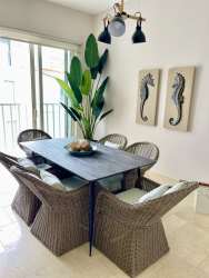 Bright dining room with wicker chairs and large window at Puntarena Buenaventura beach condo