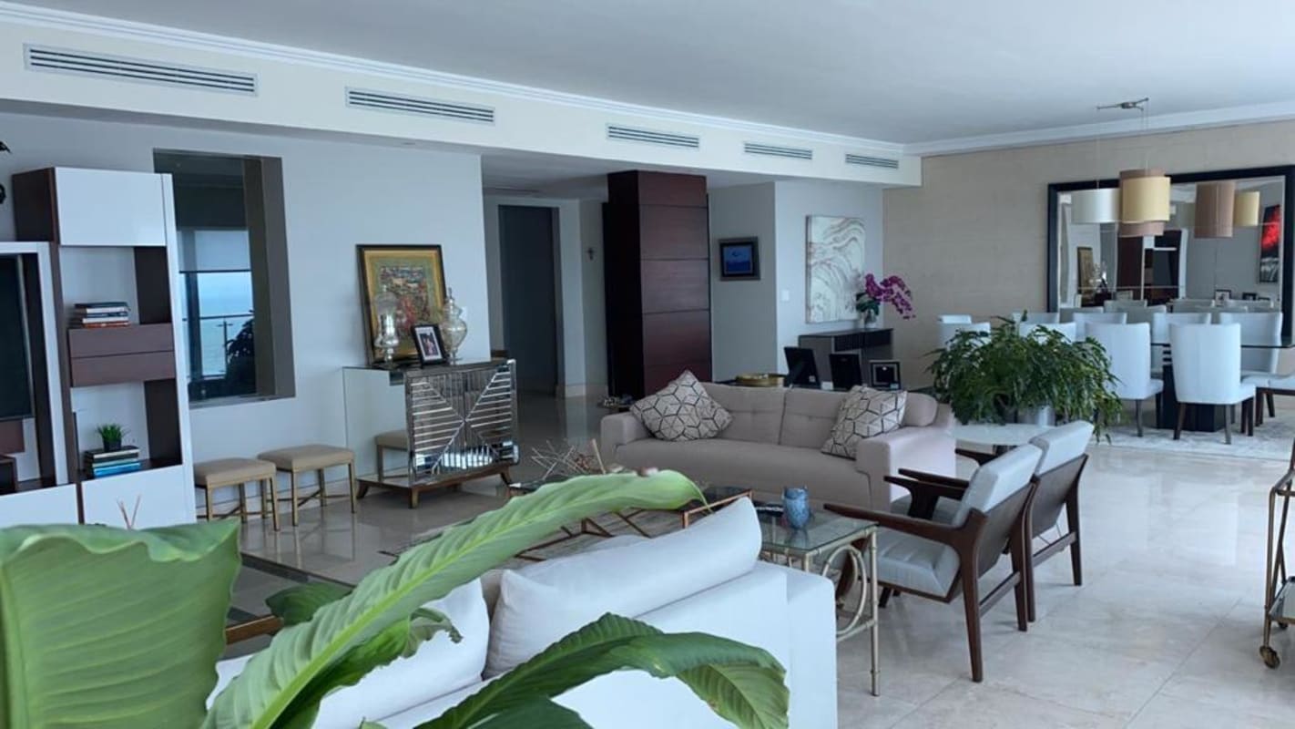 Modern dining room with glass table, upholstered chairs, balcony ocean views in PH Zeus Panama City