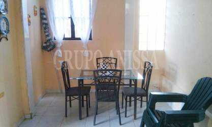 Dining room with glass-top table, metal chairs, window light in cabin Cerro Azul Panama