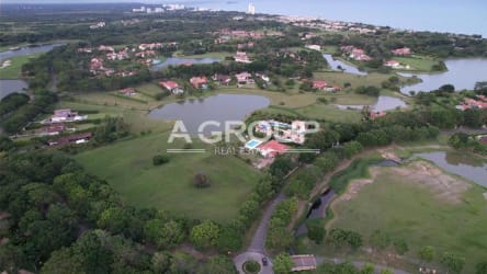 Aerial panoramic of lake, golf course, upscale residences in Buenaventura resort community, Panama