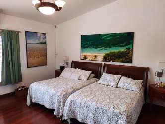 Crystal blue pool with jacuzzi, surrounded by tropical landscaping in luxury Coronado estate