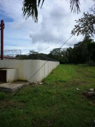 Secure fenced warehouse yard with grassy area and concrete perimeter wall in Bugaba Panama