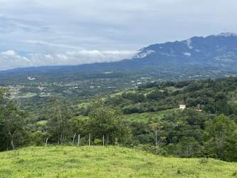 Curved paved road surrounded by dense forest on Boquete land with mountain view