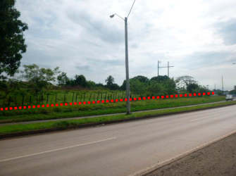 Paved road, fence line and open grassy lot with highway frontage Santiago Panama