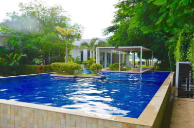 Dining table with kitchen and sliding doors to garden at Punta Chame beachfront rental villa