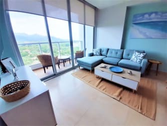 Bright living room with large windows, balcony access, and ocean mountain views at Royal Palm Panama