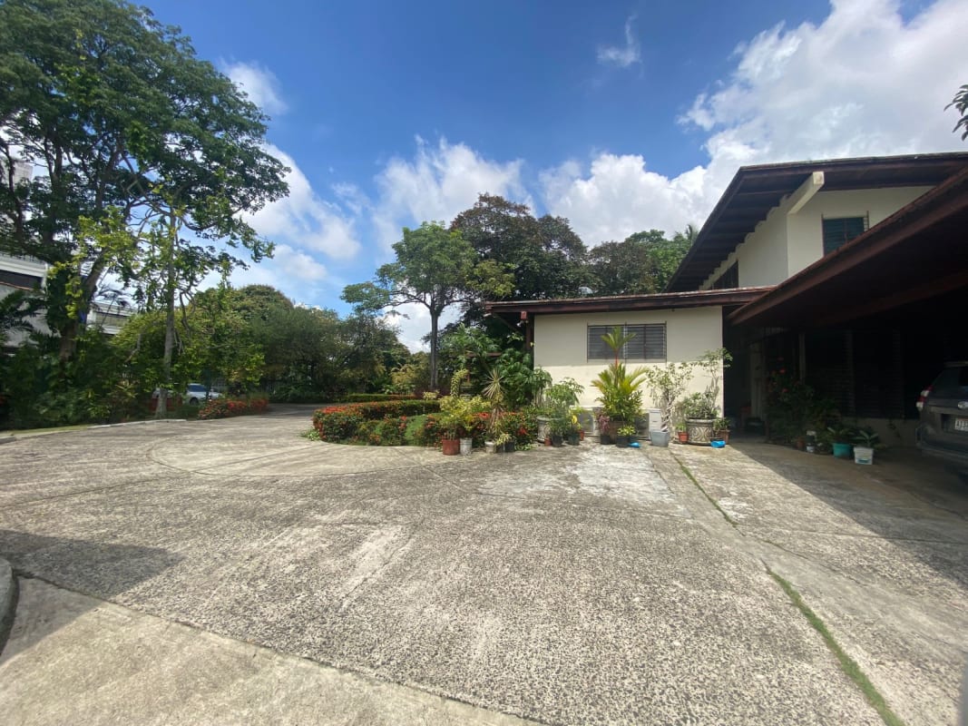 Suburban single-family home with driveway and green garden on Panama development site