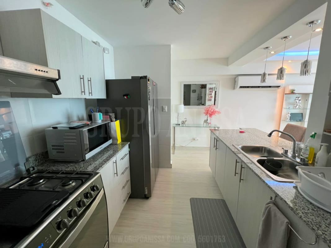 Modern kitchen with granite countertop, stainless appliances, and laundry space PH Pueblo Nuevo Panama