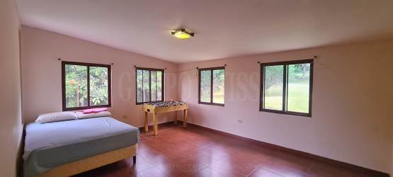 Bright kitchen with granite countertops and panoramic windows overlooking forest Altos del María Panama house