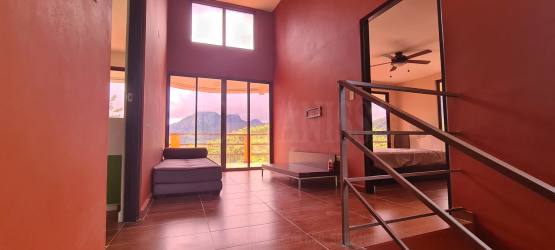 Bedroom with sliding doors to balcony, ceiling fan and mountain views in Altos del María Panama