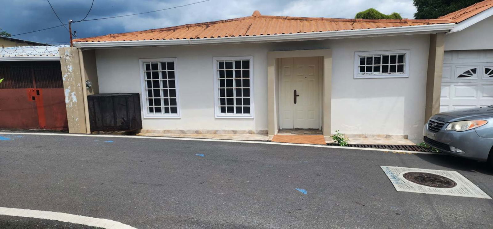 Front view house with tiled roof, garage, secure gate in Pedregal Panama City
