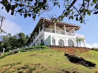 Modern kitchen with granite counters, island seating and large arched windows mountain villa Panama