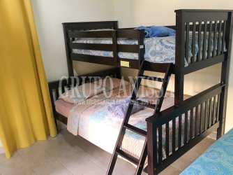 Bright bedroom with sliding glass doors to balcony mountain cabin Altos del María Panama