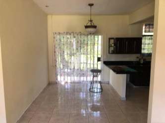 Dining space with open kitchen, light tile floors, large sliding door in Panama Howard rental home