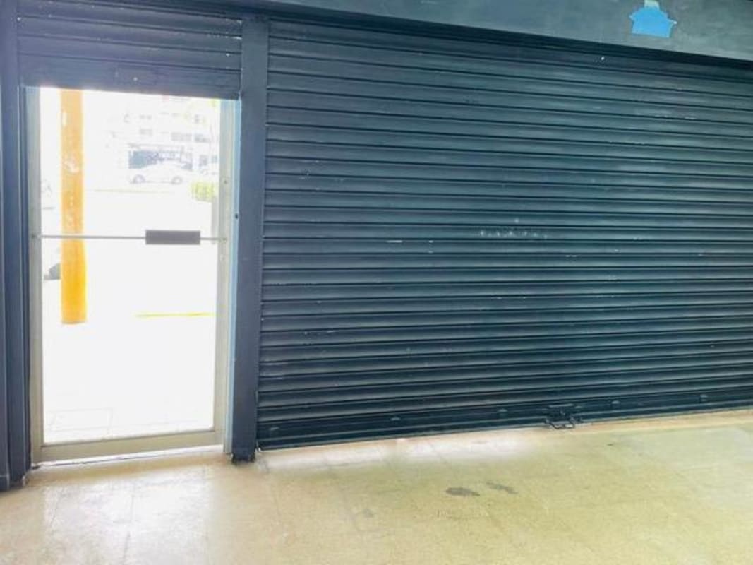 Commercial space interior with metal security shutter glass door sunlight Plaza Carolina Panama