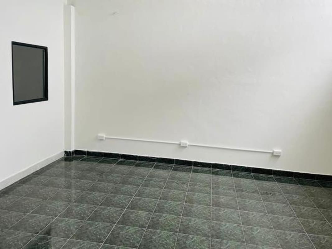 Vacant interior room with black framed window white walls tiled floor commercial space Plaza Carolina Panama
