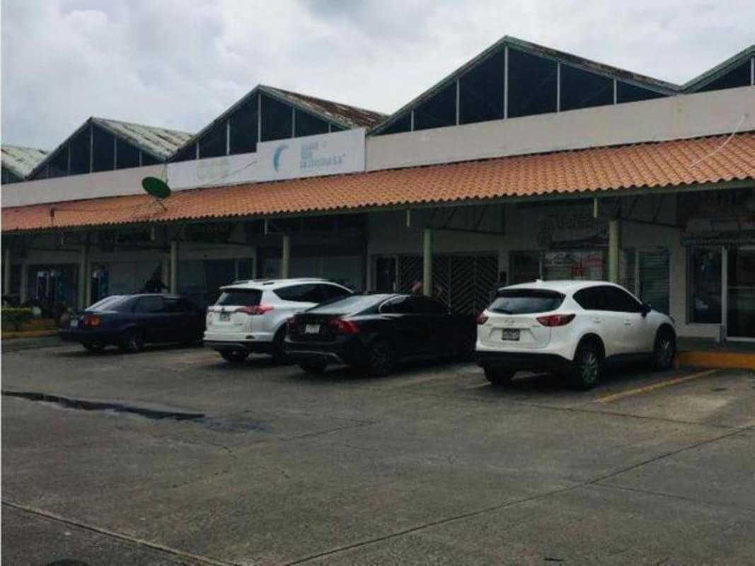 Commercial Plaza Carolina shopping center with tile roofs and parking Panama City