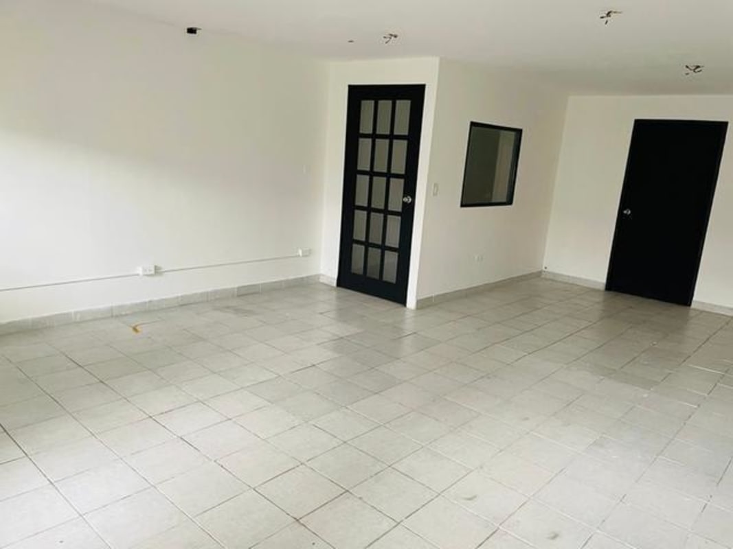 Empty commercial retail or office space with tile flooring, white walls, black doors in Plaza Carolina Panama