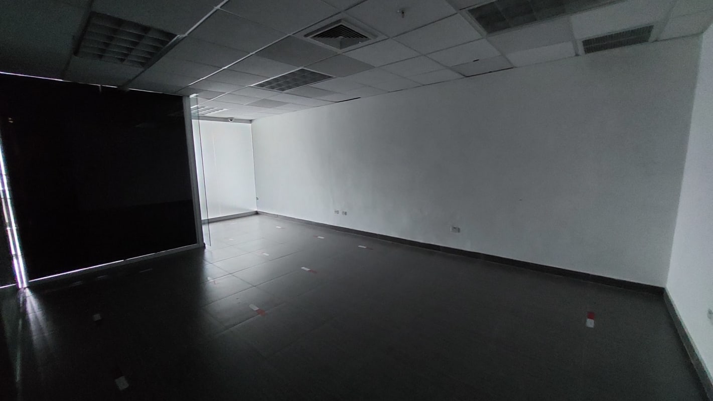 Modern small kitchenette with white cabinets black counter and window in Torre de Las Americas Panama