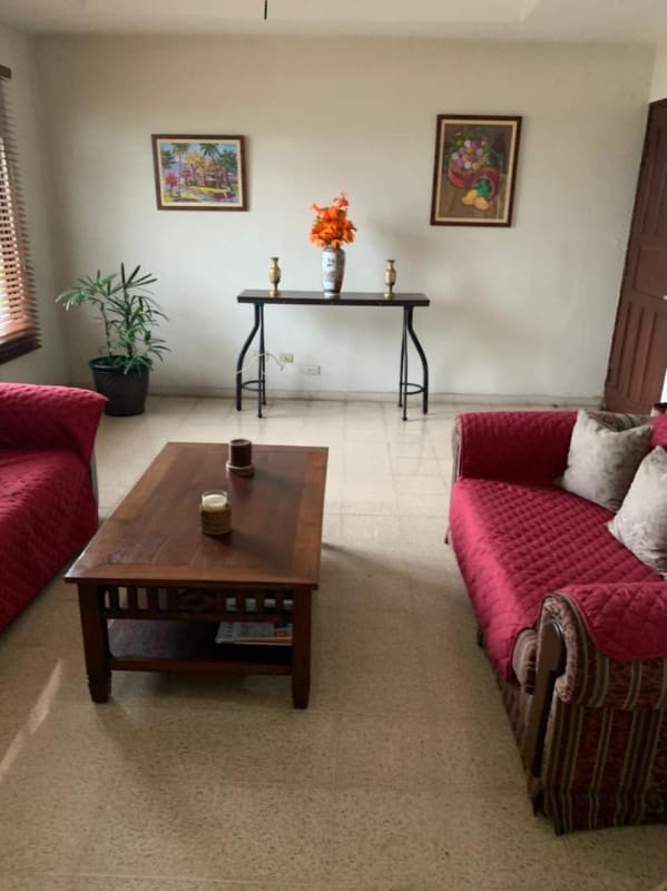 Traditional styled living room with natural light red sofas in a Panama family house