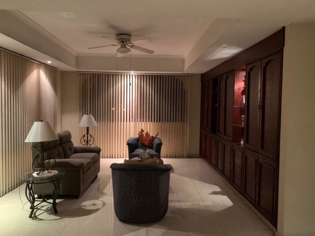 Living room with built-in shelves, vertical blinds, ceiling fan in Panama Betania district home