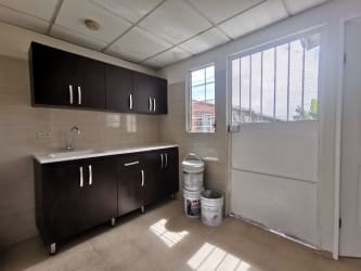 Bright kitchen with dark wood cabinets and large window in affordable house Altos del Tecal Panama