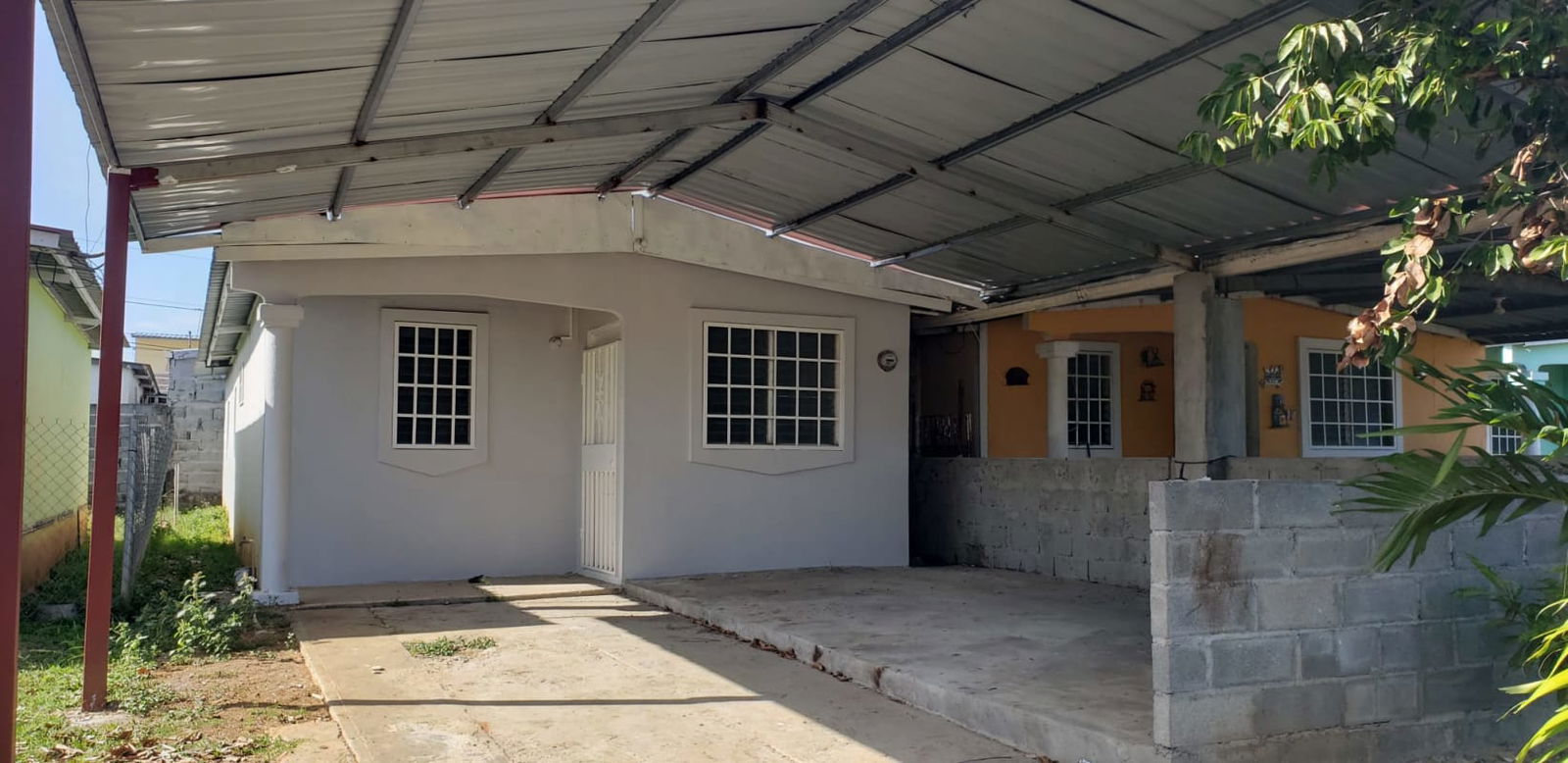 Single-story house with metal carport and concrete driveway in gated community Tocumen Panama
