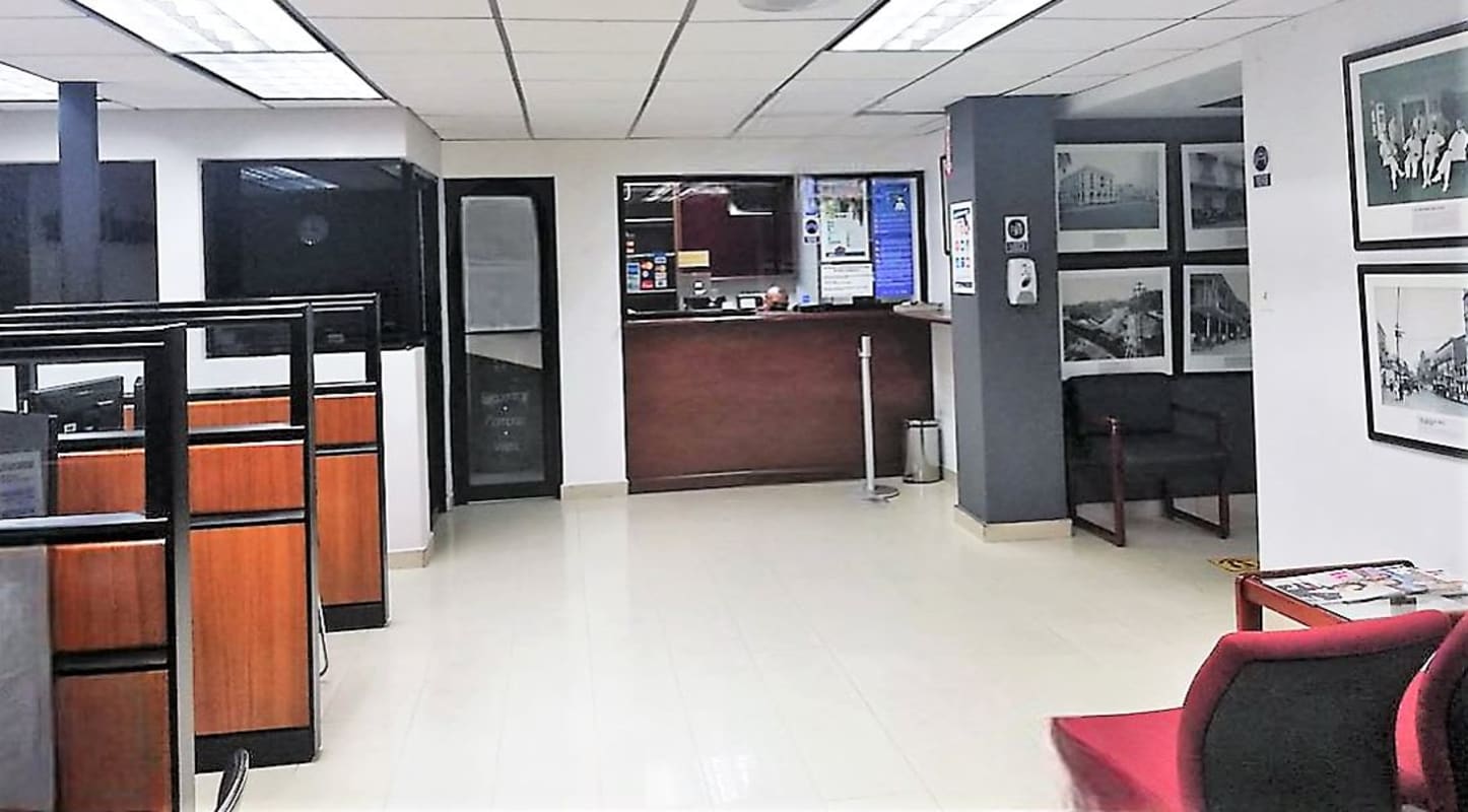 Office reception area with desk, glass doors, waiting chairs and modern decor in PH BICSA Tower Panama City