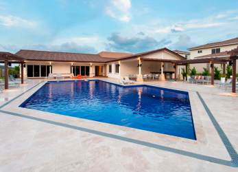 Secure gated entry of Bosques del Pacífico community with landscaped greenery Panama