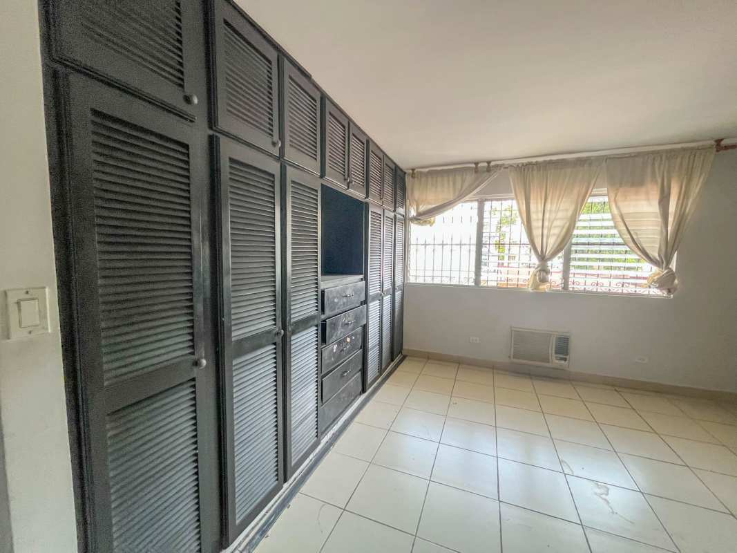 Spacious bedroom with built-in black closet, tile floors and large window in PH Aileen El Carmen Panama