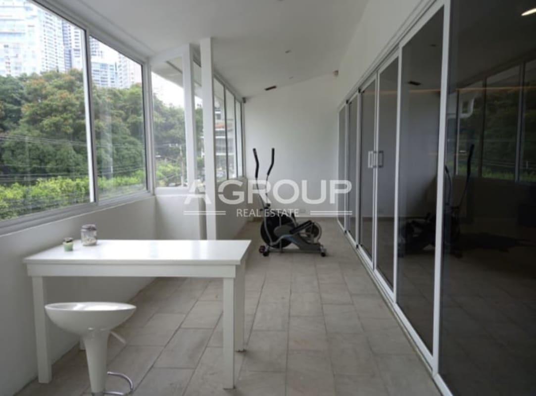 Bright enclosed glass sunroom overlooking garden in Punta Paitilla luxury home