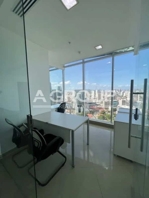 Glass-enclosed office section inside commercial space at Revolution Tower Panama with skyline view