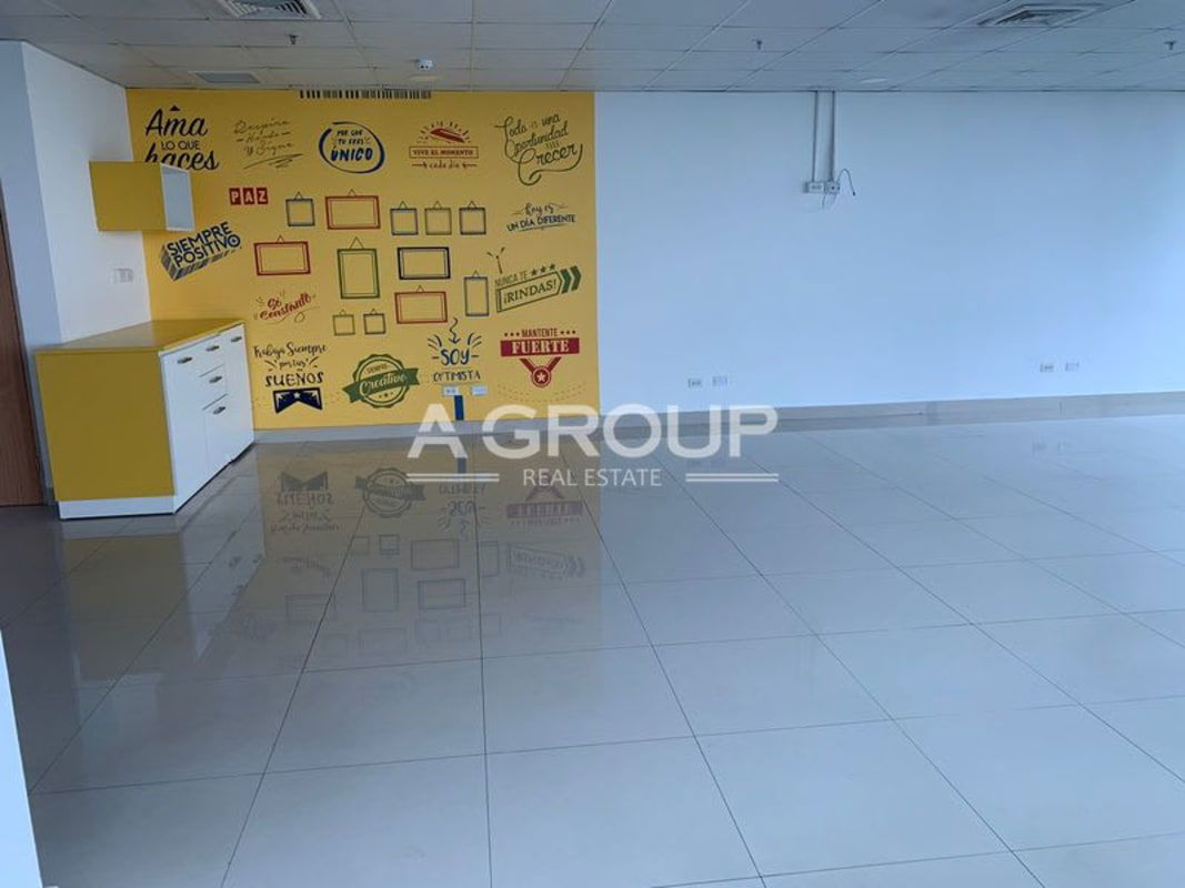 Modern office space with colorful geometric accent wall, cubicles, and large glass windows in Financial Park