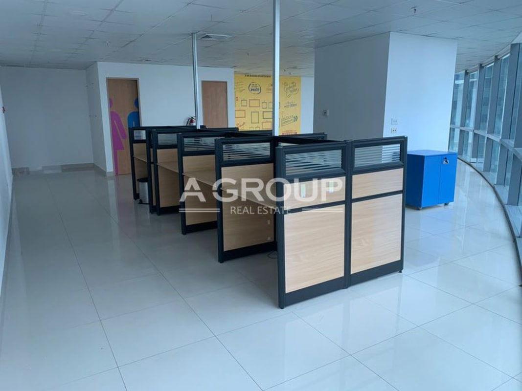 Modern open office interior with large floor-to-ceiling windows overlooking the Costa del Este skyline