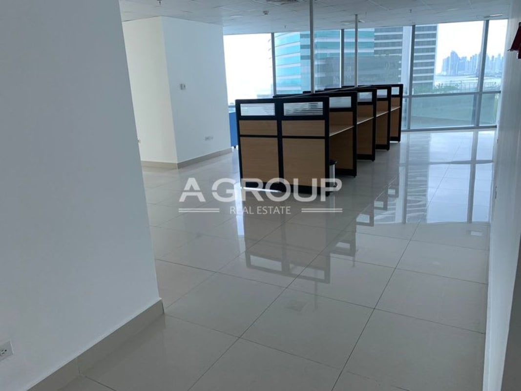 Modern office with glass dividers and cubicles offering city views at Financial Park