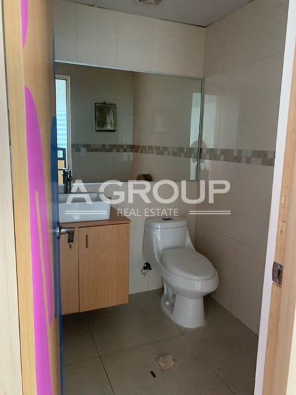 Modern bathroom with vanity, cabinet, and beige tiled wall in Financial Park tower Panama