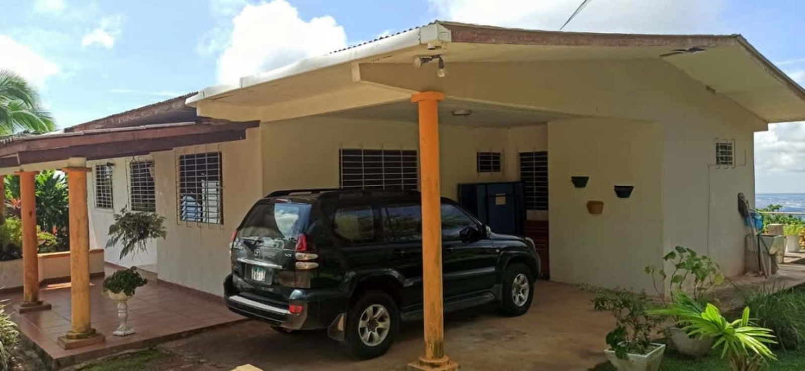 Large living room with tile floors surrounded by windows overlooking gardens Cerro Azul estate Panama