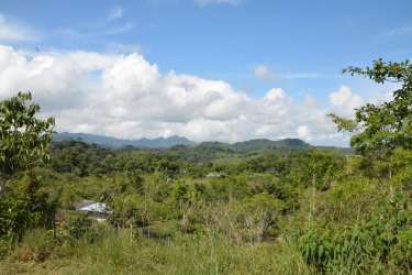 Green terrain with rolling hills and clouds on rural land in Capira Panama