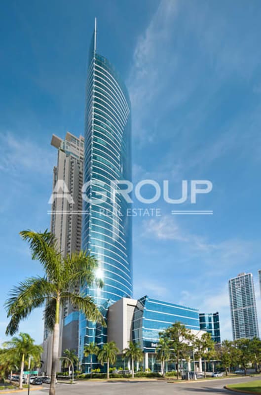 Glass facade office tower with palm trees in Costa del Este Panama City