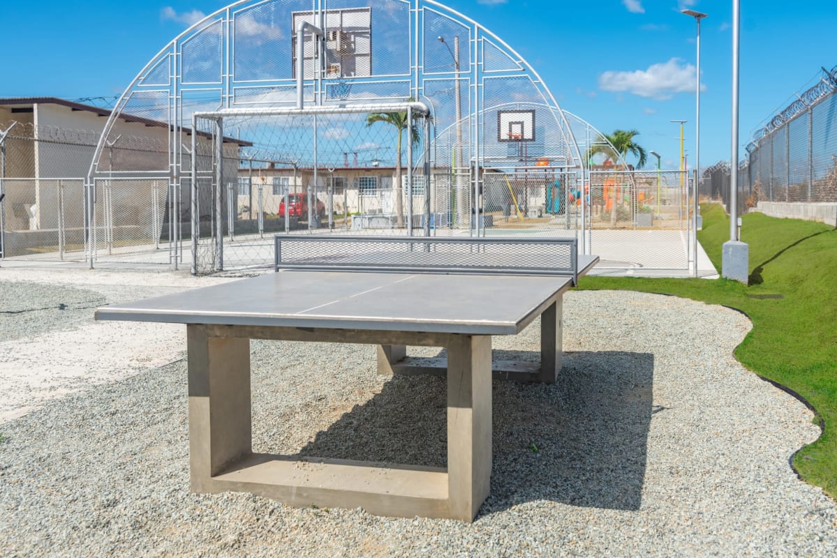 Outdoor basketball and ping pong courts with fencing in affordable Viñedo residential project Pacora Panama