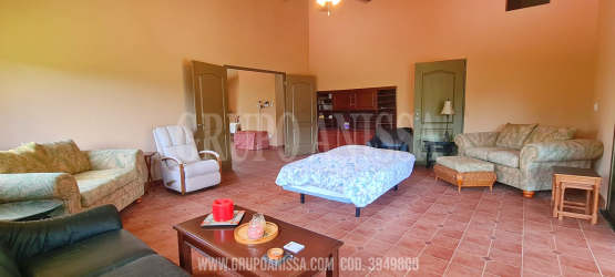 Living room with panoramic corner windows showing hills and forest