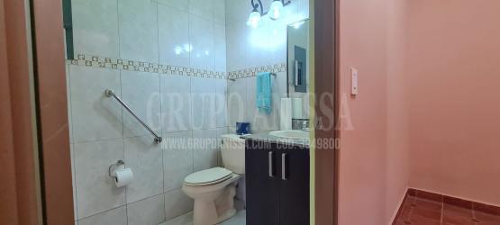 Large kitchen with granite counters, dark cabinetry, and windows to garden