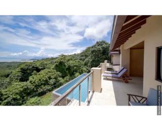 Gourmet kitchen with rainforest stone counter, stainless appliances, and breakfast island in luxury countryside villa Panama Oeste