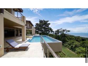 Spacious open-plan living room with vaulted ceilings, large windows and dining area in a hilltop villa Panama Oeste