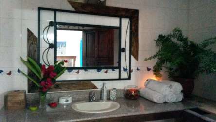 Bathroom vanity with decorative framed mirror and stone counter in Las Uvas villa San Carlos Panama