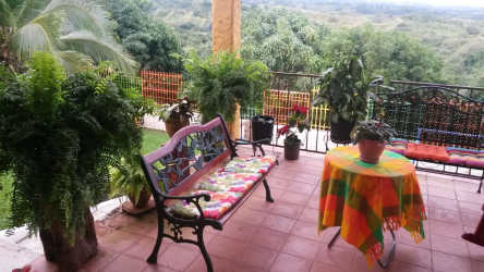 Patio with colorful furniture lush plants overlooking nature in Las Uvas villa San Carlos Panama