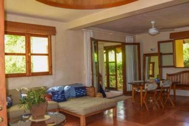 Rustic living dining room with wood furniture, patio doors Azueros Ocean Loft Pedasi Panama
