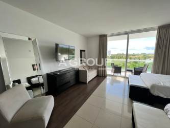 Bright studio with two beds, TV and balcony overlooking resort lagoon at Playa Blanca Panama
