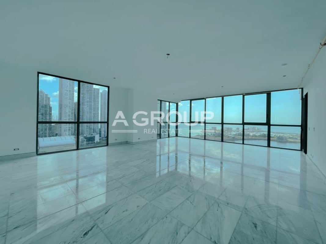 Modern living room with marble floors and panoramic floor-to-ceiling windows overlooking Panama Bay in Sea Point Punta Paitilla