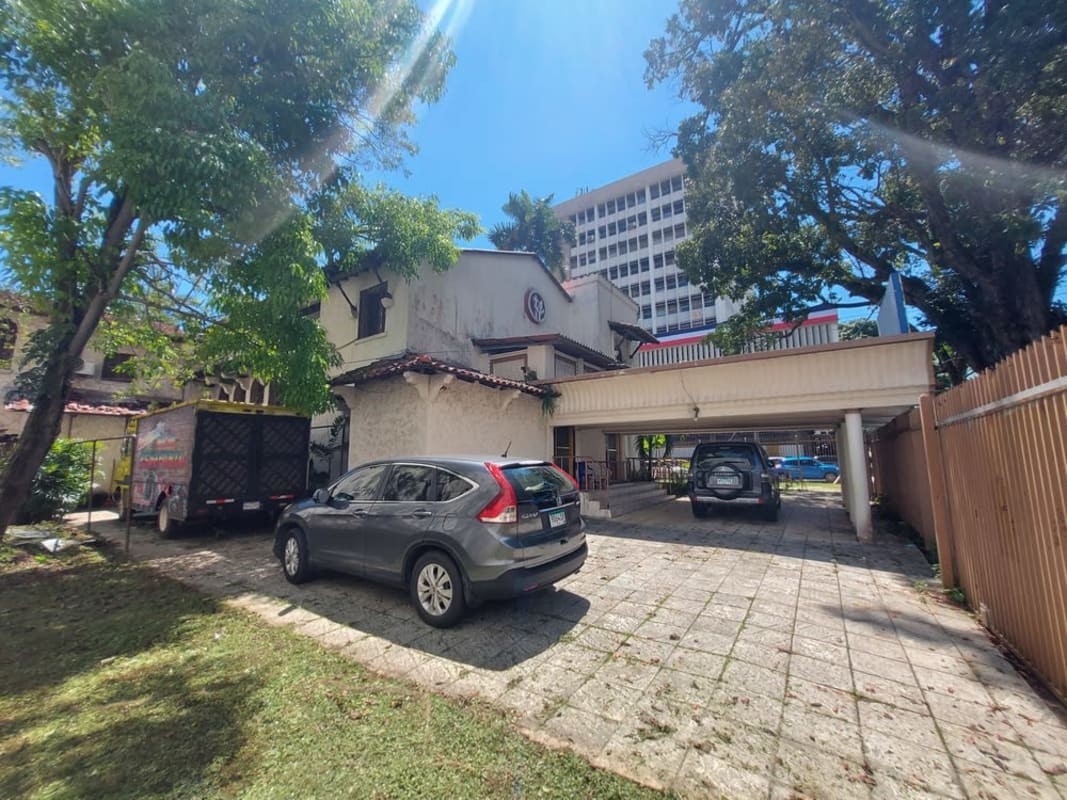 Panoramic of two-story white historic building with carport mature trees and driveway Calidonia Panama City